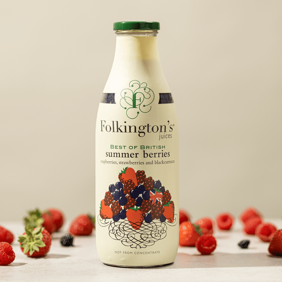 1 litre Summer Berries fruit juice standing on a table amongst a scattering of natural berries.