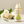 Load image into Gallery viewer, Open bottle of 250ml Apple Juice on a counter with a bunch of white roses and green leaves laying in the background.

